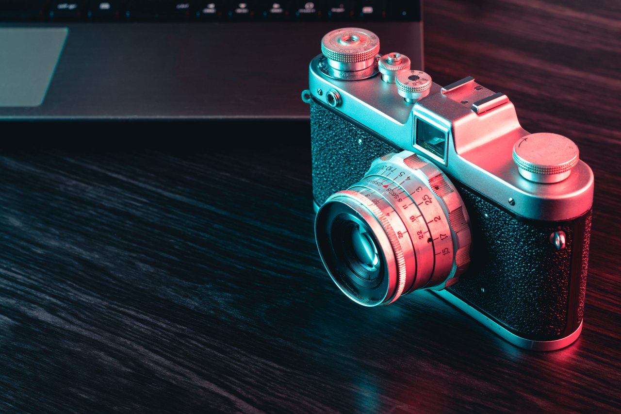 old-film-camera-and-laptop-on-table-blue-and-red-2023-11-27-05-26-08-utc. png
